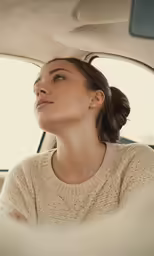 woman in the back seat of a car, looking up