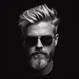 a man with a beard and sunglasses looks into the distance