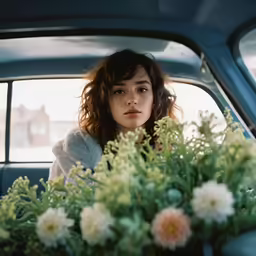 a person in a car with flowers on the dashboard