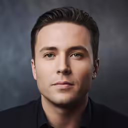 this man has brown hair and a black shirt