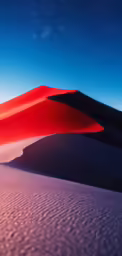 a desert sand dune with sky and stars in the background