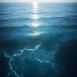 blue water waves and the sun on the horizon