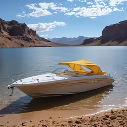 a white boat on the shore near some mountains