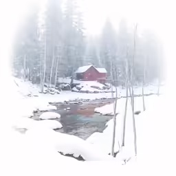 snow covered river in front of a house