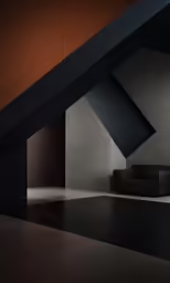 black couch and dark geometric structure in a dimly lit room