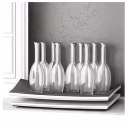 five silver pitchers sitting on top of a book