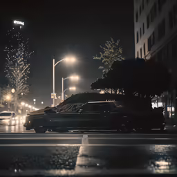 cars drive down a city street at night