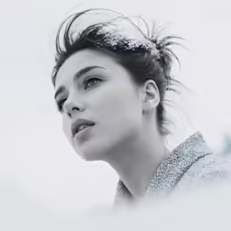 a beautiful woman looking down at something in the distance