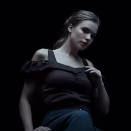 young woman wearing black top and dark pants posing for photo shoot