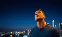 a man looks up in the dark by the city