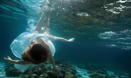 there is a person swimming and one leg visible under water