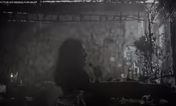 the silhouette of a woman in front of candles
