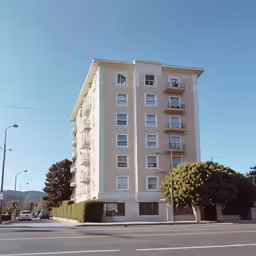 a three story building on the corner of the road