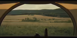 the view from inside a camper window of a field