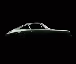 a car is silhouetted in a black background,an old car sitting in the dark on a black background