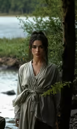 a woman with long hair standing by water