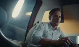a man in a white shirt working on his laptop