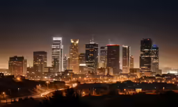 the city lights shine brightly as it glows in the night sky
