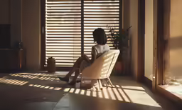 a person sitting in a chair near a wall
