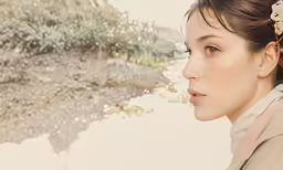 a woman with floral hair clip looking down at the ground