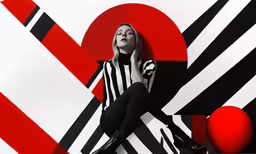 a woman sitting on a striped wall with her feet up
