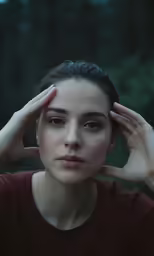 a young woman holding her hands to her head and staring