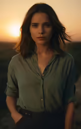 young woman looking off into the distance at sunset