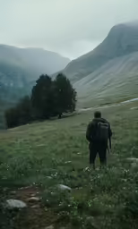there is a man in the mountains with backpack