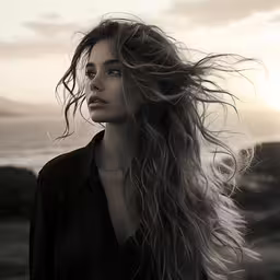 woman with long hair in front of ocean,a woman with long hair standing at the beach