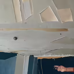 a person points to a torn up area with various different items on it
