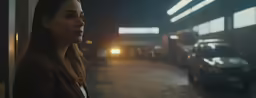 a woman standing near a building at night