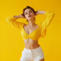 the model wears a yellow top with white shorts and high heels