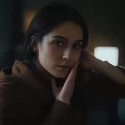 a girl sitting down and touching her hand