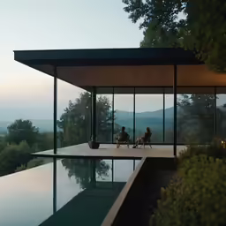 two people sitting at the edge of a swimming pool