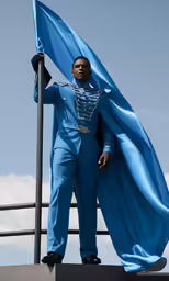a man dressed in blue is standing at the top of a platform