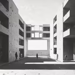 the people are walking through the courtyard next to tall buildings