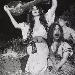 black and white photo of three women sitting on the ground