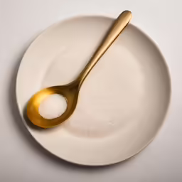 sugar and spoon sitting on top of a plate