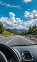 a car driving down an empty road on a sunny day