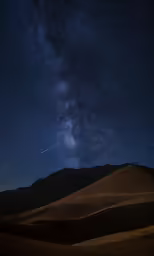 a view of some desert hills with stars