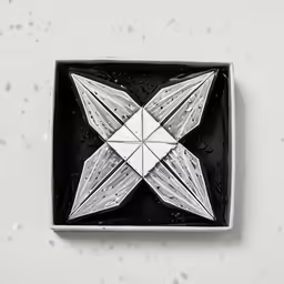 a silver square with a white star made out of silver thread