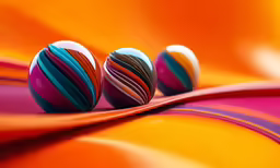 some very colorful balls near each other on a yellow and red background