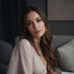 a woman sitting on the couch wearing white top