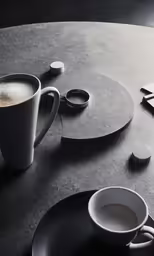black and white cups with liquid are sitting on a table