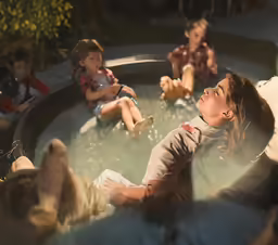 three children are sitting in a water pool