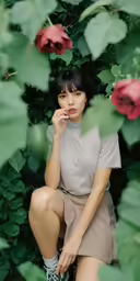 a young asian woman posing with her hands to her lips
