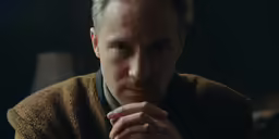 a man who is looking down with his finger on the chin