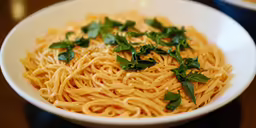 pasta with fresh herbs is sitting on a table