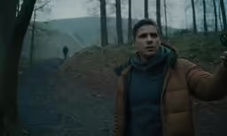 a man standing on a road holding a camera