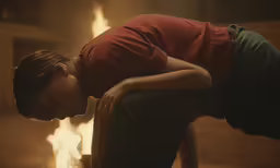 the woman is sitting in front of the fireplace